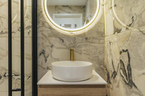 a bathroom with a white sink and a mirror at The Old Quay House Hotel in Fowey
