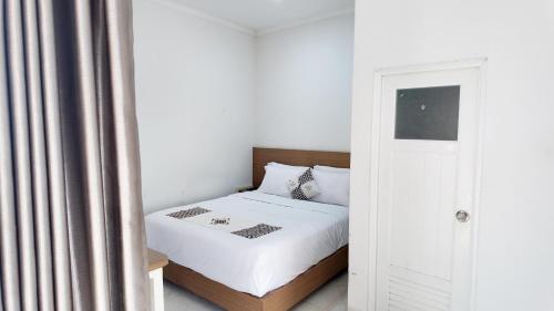 - une petite chambre avec un lit et une porte dans l'établissement Damar Kusumo Exclusive Guest House, à Seturan