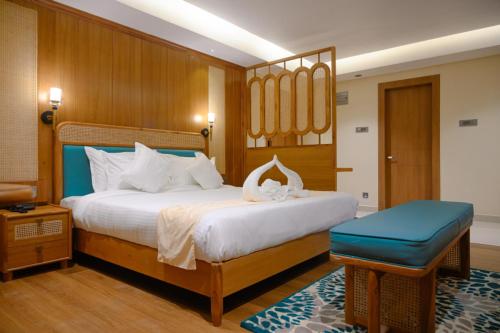 a bedroom with a large bed with a blue stool at The Shining Sun in Bhutiāgāon