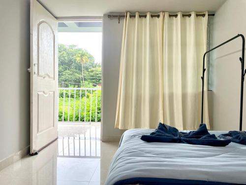 a bed with blue pillows in a room with a window at Wavehouse Retreat 1bhk with free Parking anirah in Colva