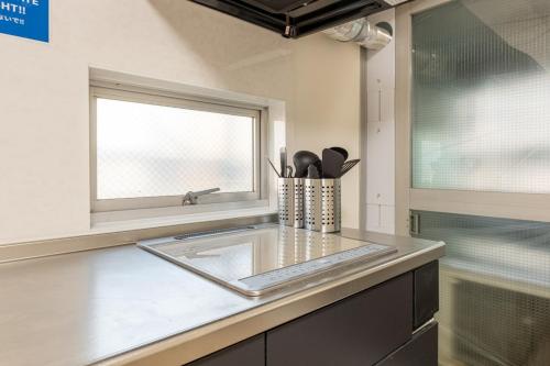 a kitchen with a sink and a window at 東新宿1007 Good location within 15 minutes of Shinjuku Station in Tokyo
