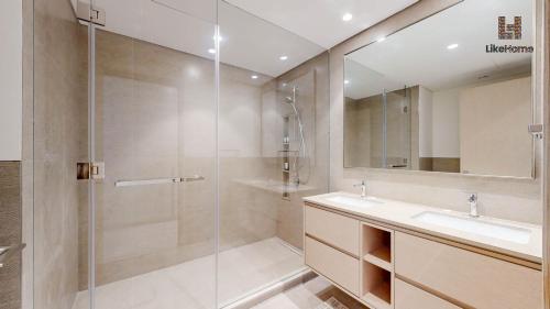 a bathroom with a shower and a sink and a mirror at Direct Burj Khalifa & Fountain Views from Balcony ,Next to Dubai Mall Luxury 2 Bedroom - Like Home in Dubai