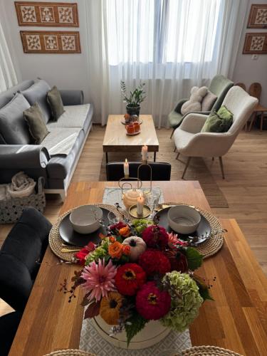 a living room with a table with flowers on it at Emerald Chalet in Praid