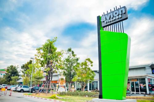 a green and white sign in front of a store at Avion Hotel in Lat Krabang