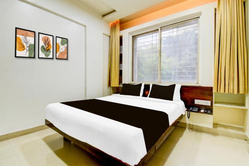 a bedroom with a large bed in front of a window at Super Collection O Balewadi formerly Woods Regency in Pune