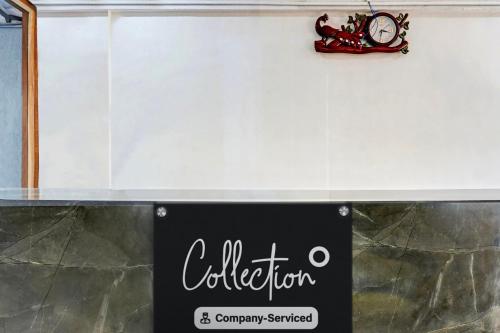 a sign for a store with a clock on a wall at Super Collection O Balewadi formerly Woods Regency in Pune