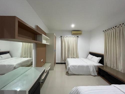 a hotel room with two beds and a desk at Villa Sahadewa Pecatu in Uluwatu