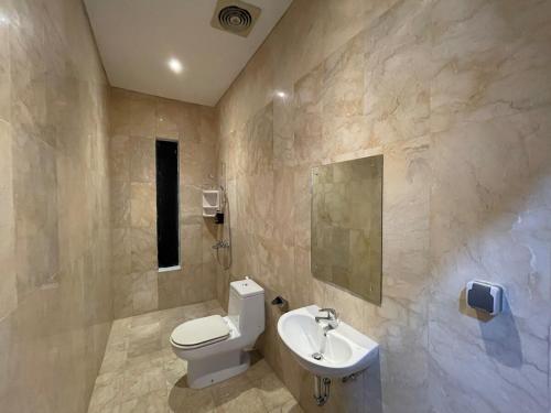 a bathroom with a toilet and a sink at Villa Sahadewa Pecatu in Uluwatu