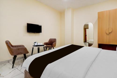 a hotel room with a bed and a tv at Super Townhouse Oak Army Aviation Base Jhansi in Jhānsi