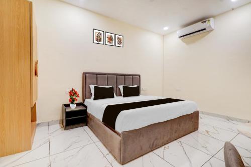 a bedroom with a large bed with white walls at Super Townhouse Oak Army Aviation Base Jhansi in Jhānsi