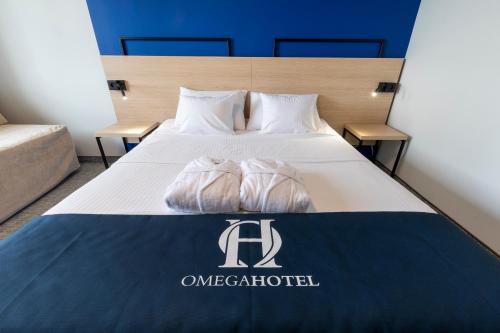 a hotel room with a bed with two towels on it at Omega Hotel in Olsztyn