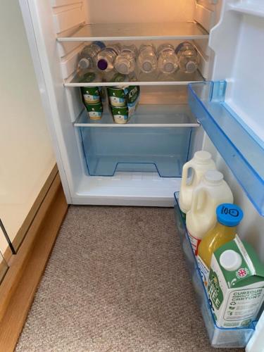 an open refrigerator with food and drinks in it at Roselands B&B Henley on Thames in Nuffield