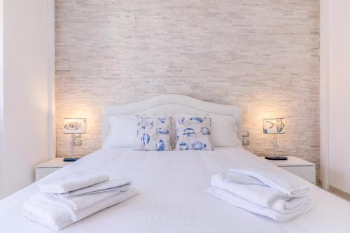 a bedroom with a white bed with towels on it at Relais Roma Beach in Fregene