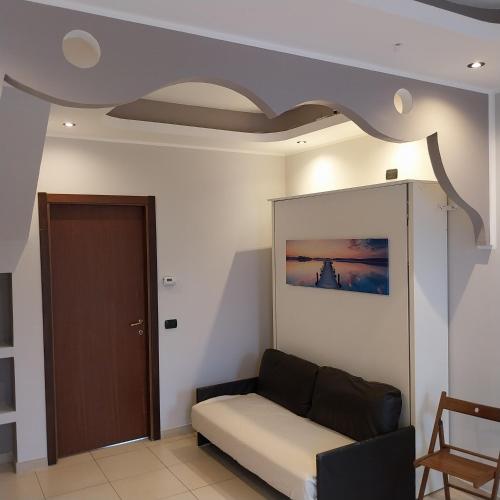 a living room with a couch and a ceiling at B&B linate in Peschiera Borromeo