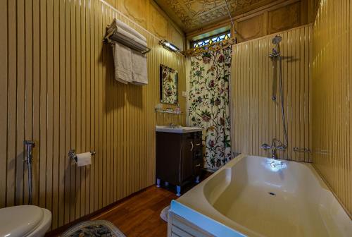 une salle de bain avec une baignoire, des toilettes et un lavabo dans l'établissement Dastan Heritage Houseboats, à Srinagar