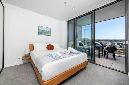een slaapkamer met een bed en een balkon bij Chic 2 Bedroom Escape with Premium Amenities in Phillip