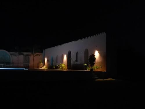 a night view of a white building with lights at Dahleez Resort Mandawa in Mandāwa