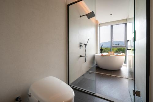 a bathroom with a tub and a toilet and a sink at Hidden Travel Shenzhen Dapeng in Dapeng
