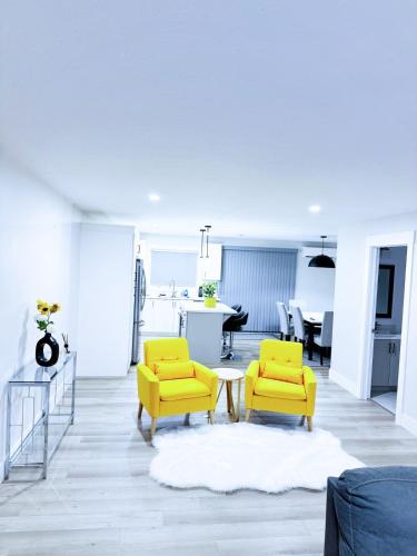 a living room with two yellow chairs and a table at Luxury 3-Bedroom Full House Near Magnetic Hill in Moncton