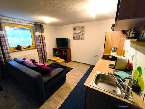 a living room with a couch and a kitchen at Ferienwohnung Finala in Gaschurn