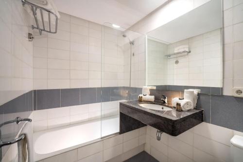 un baño con lavabo y bañera en Apartaments Blau by Marsol, en Lloret de Mar