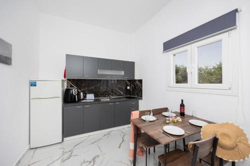 a kitchen with a wooden table and a refrigerator at Kosmas Apartments in Roda