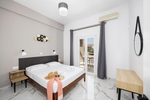 a bedroom with a bed and a table with a hat on it at Kosmas Apartments in Roda