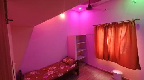 a bedroom with a bed and a pink light at Bnr babu naidu residency unit 2 in Vellore