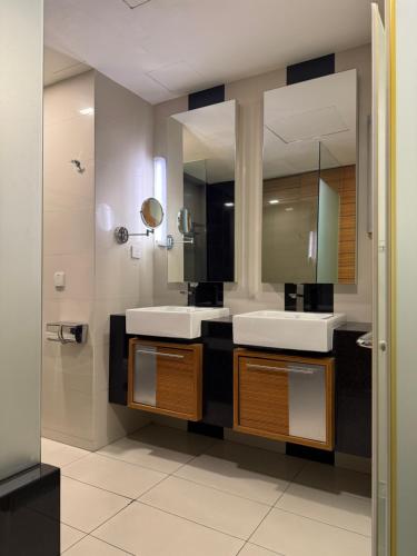 a bathroom with two sinks and a large mirror at Family Suites KL Sentral in Kuala Lumpur