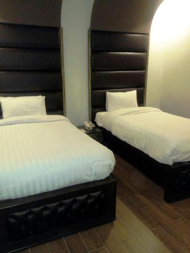 two beds in a hotel room with two bedsskirts at Shalimar Hotel in Multan