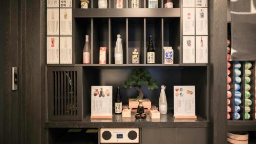 a shelf filled with bottles of wine and books at Workers Hotel Daejeon by Aank in Daejeon