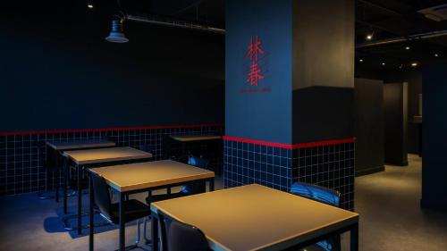 a row of tables in a room with a chinese sign at Workers Hotel Daejeon by Aank in Daejeon