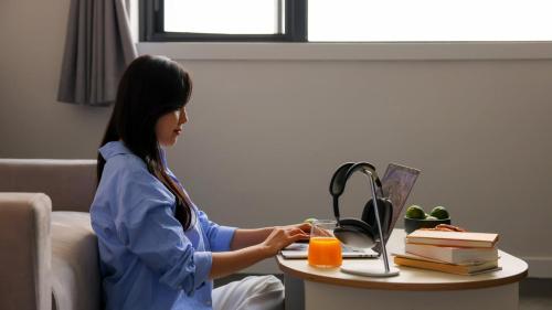 a woman sitting at a table with a glass of orange juice at Workers Hotel Daejeon by Aank in Daejeon