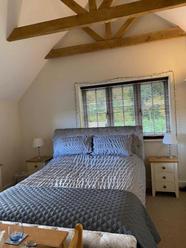 a bedroom with a bed and a large window at Roselands B&B Henley on Thames in Nuffield