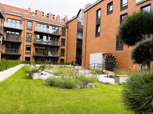 a garden in front of a brick building at Justinrent PALATIUM 13 in Legnica