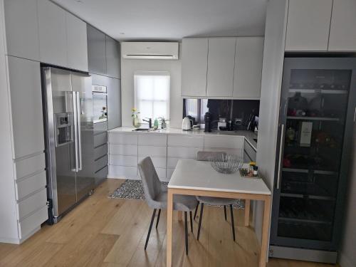 a kitchen with white cabinets and a table and chairs at Winelands Golf Lodges 34 at De Zalze in Onder-Papegaaiberg