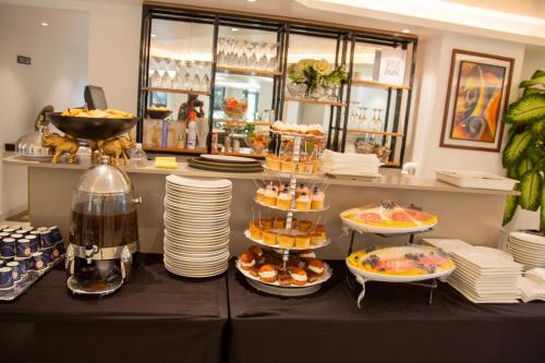 a buffet with plates and desserts on a table at AXIL HÔTEL in Dakar