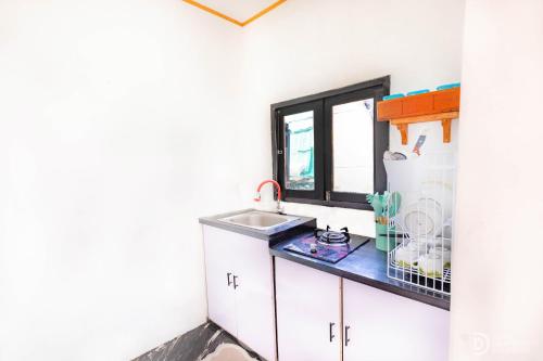 a kitchen with a sink and a window at Zaa Villa in Dieng