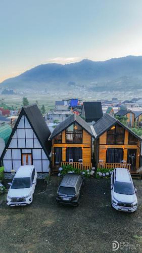 two cars parked in a parking lot in front of a house at Zaa Villa in Dieng