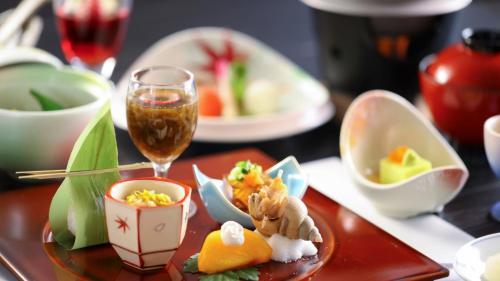 a table with a plate of food and a glass of wine at Hotel Asafuji in Fujikawaguchiko