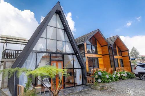 a glass house with a pyramid facade at Zaa Villa in Dieng