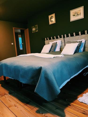 a large bed with a blue blanket on top of it at Rustic Haven in La-Roche-en-Ardenne