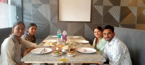 un grupo de personas sentadas en una mesa en un restaurante en Hotel Simla, en Siliguri