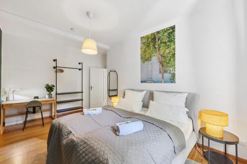 a white bedroom with a bed and a desk at Lemon3 - Karlsruhe Beiertheim in Karlsruhe