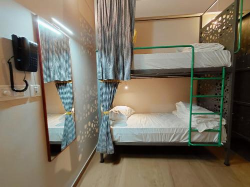 a room with two bunk beds and a mirror at Zostay Urban Retreat Deluxe Rooms & Premium Dorms in Manjeri