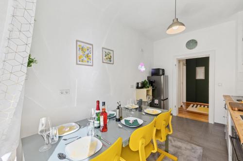 a dining room with a table and yellow chairs at Lemon3 - Karlsruhe Beiertheim in Karlsruhe