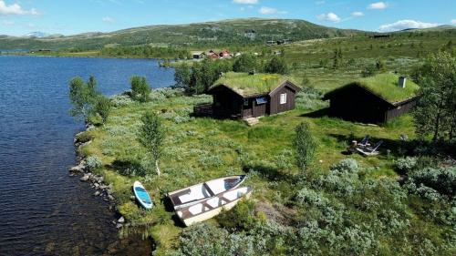 an island with a house and a boat in the water at Fiskebu at Flaksjøen in Venabygd
