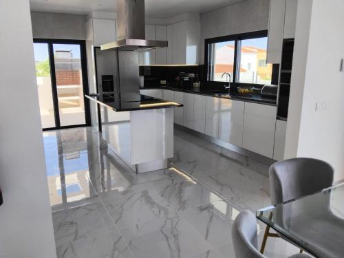 a kitchen with a marble floor and a stove at Villa Paraiso in Alcantarilha