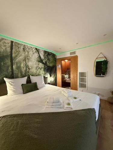 Un dormitorio con una gran cama blanca con toallas. en Spa et sauna - Loft Cataleya, en Belfort