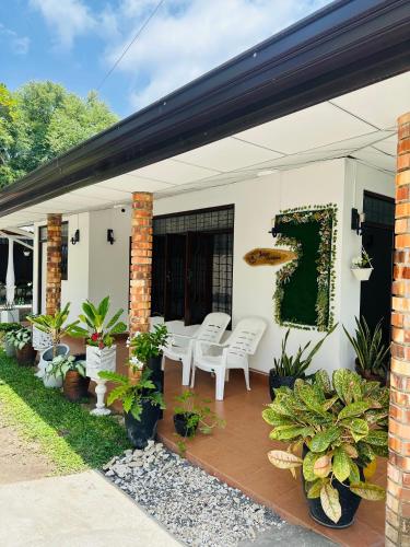 a patio with white chairs and potted plants at Jaya Residence - Near Airport in Negombo